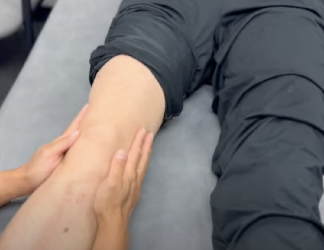 Knee examination by physiotherapist on a table.